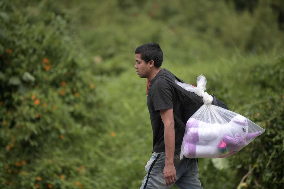 Migrantes venezolanos transitan por la autopista norte de Bogotá de regreso a Venezuela, en medio de la cuarentena obligatoria por cuenta del Covid-19.