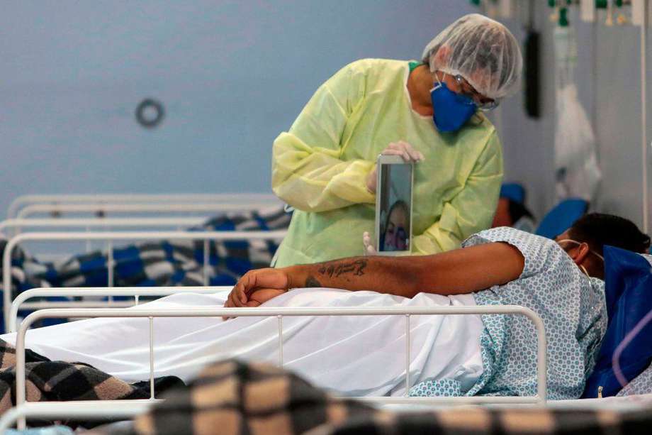 Un médico en un hospital de Brasil ayuda a un paciente con COVID-19 a hablar con su familia a través de una tablet.