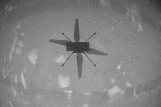 El helicóptero Ingenuity Mars de la NASA capturó esta toma mientras flotaba sobre la superficie marciana el 19 de abril de 2021, durante la primera instancia de vuelo controlado y motorizado en otro planeta. Usó su cámara de navegación, que rastrea de forma autónoma el suelo durante el vuelo.