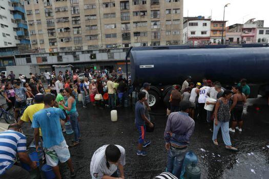 Los transportistas tienen que recoger agua en los “llenaderos” de Hidrocapital, y luego llevan el líquido a los barrios venezolanos. / EFE