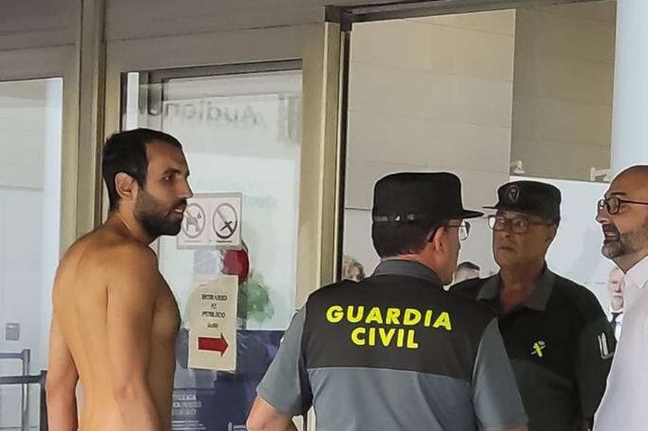 El joven desnudo habla con los agentes de la Guardia Civil a la entrada de los juzgados de Valencia.
