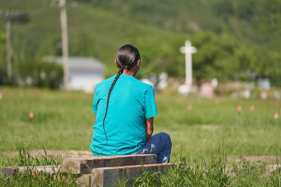 Un hombre sentado frente al lugar donde hubo un convento en el que fueron encontradas las 750 tumbas de indígenas canadienses.