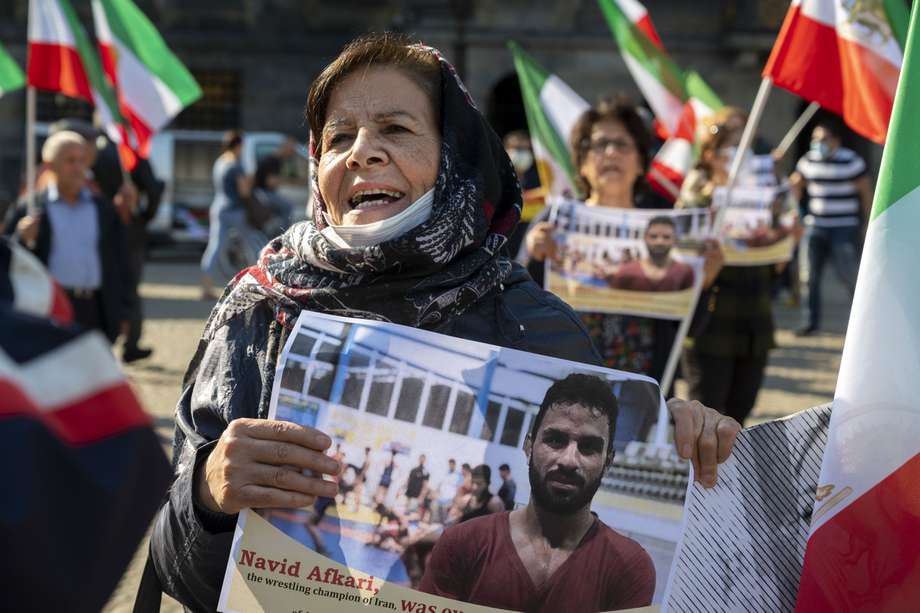 Una mujer sostiene un retrato del luchador iraní Navid Afkari durante una manifestación en la Plaza Dam, en Ámsterdam, contra su ejecución en la ciudad de Shiraz, en el sur de Irán /AFP