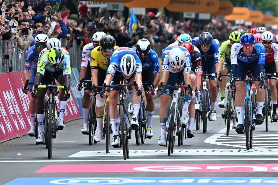 El ciclista belga Tim Merlier (C) de Soudal Quick-Step cruza primero la línea de meta y gana la tercera etapa del Giro de Italia 2024, una carrera ciclista de 166 km desde Novara a Fossano, Italia, el 6 de mayo de 2024.