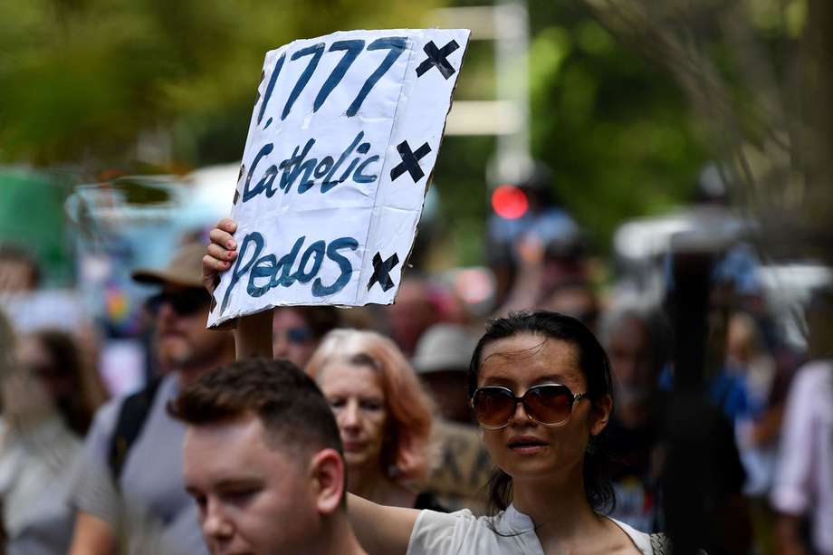Manifestantes sostienen pancartas mientras marchan en apoyo a los sobrevivientes de abusos sexuales por parte del clero y a la comunidad LGBTQI+, mientras se lleva a cabo la misa pontificia de réquiem por el cardenal George Pell en St. Mary's Cathedral en Sydney.
