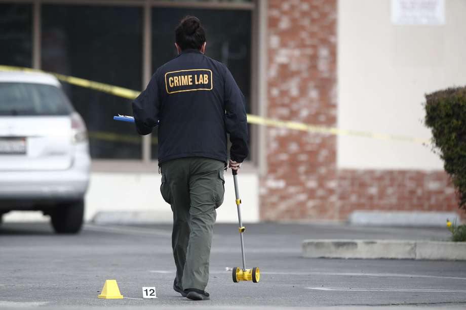 El equipo de criminalística recoge pruebas en un aparcamiento tras un tiroteo masivo en un estudio de danza en Monterey Park, California.