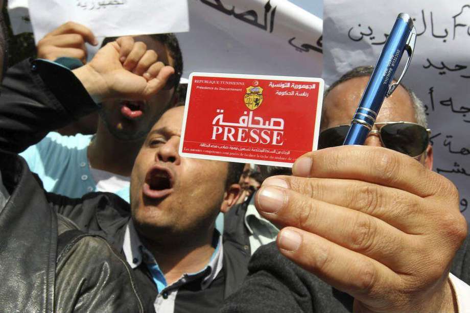 Un periodista tunecino muestra su credencial de prensa durante una manifestación celebrada con motivo del Día Mundial de la Libertad de Prensa.