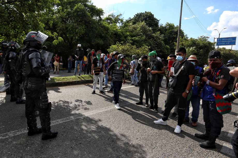Indígenas realizan un bloqueo en una calle hoy en Cali. Varias autoridades denunciaron que este domingo supuestos civiles armados dispararon contra un grupo de indígenas que estaban manifestándose a las afueras de la capital del Vale del Cauca.
