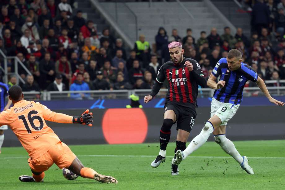 El portero del AC Milan, Mike Maignan, hace una atajada contra Edin Dzeko, del Inter de Milán, durante el partido de ida de la semifinal de la Liga de Campeones de la UEFA entre el AC Milan y el FC Inter.