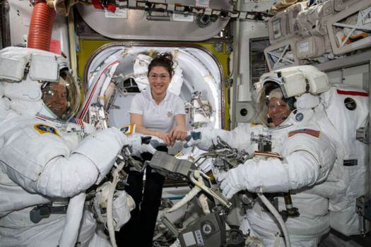 La astronauta de la NASA Christina Koch (centro) asiste a sus compañeros astronautas Nick Hague (izquierda) y Anne McClain (derechea) para ajustar sus trajes espaciales poco antes de comenzar su primer paseo espacial el pasado 22 de marzo. / NASA