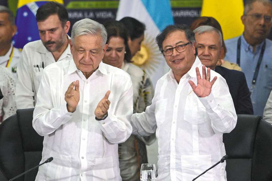 Colombian President Gustavo Petro (R) waves next to his Mexican counterpart, Andres Manuel Lopez Obrador, during the Latin American and Caribbean Conference on Drugs at the Valle del Pacifico Event Center in Cali, Colombia, on September 9, 2023. (Photo by JOAQUIN SARMIENTO / AFP)