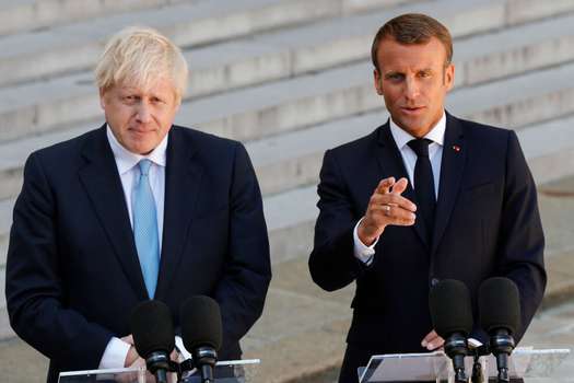 El primer ministro británico, Boris Johnson (i) y el presidente de Francia, Emmanuel Macron (d) hablan sobre el brexit. / AFP