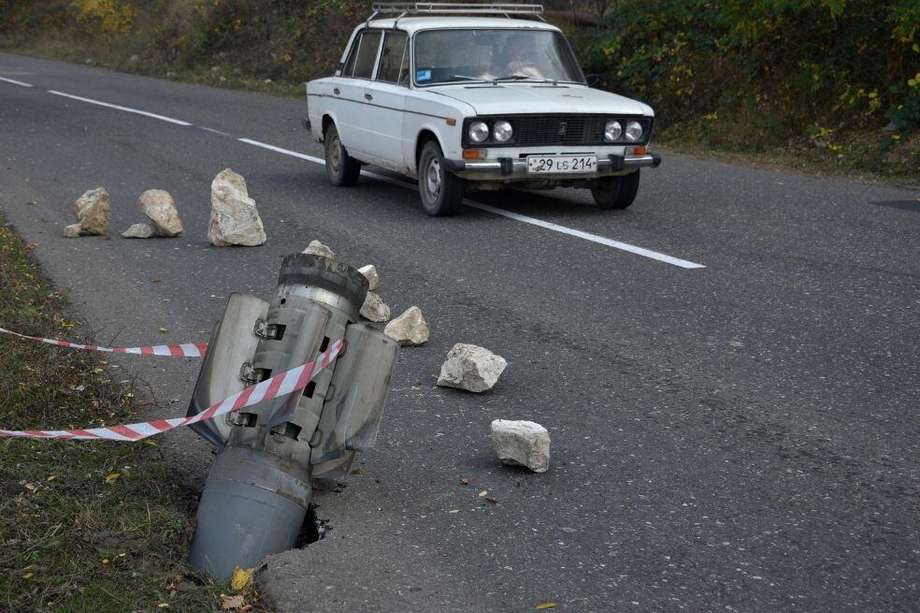Un automóvil pasa junto a los restos de un cohete en una carretera cerca de la ciudad de Shusha, provincia de Nagorno-Karabaj. El conflicto entre Armenia y Azerbaiyán en esta zona separatista continúa.