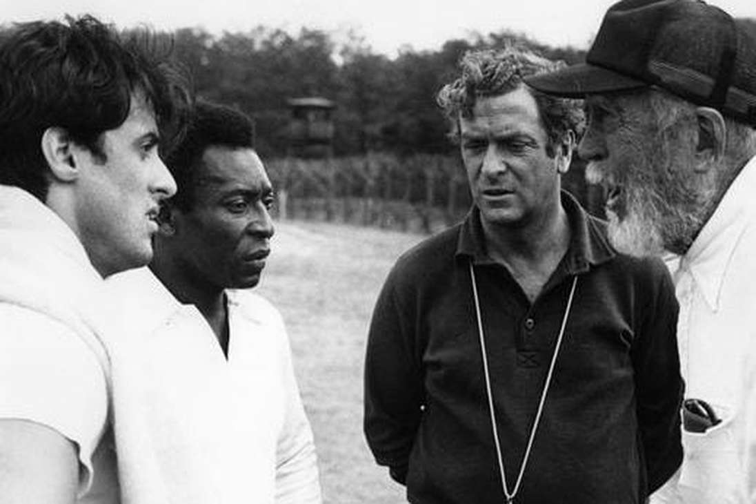 Sylvester Stallone, Pelé, Michael Caine y el director John Huston, en la filmación de la película "Escape a la victoria" de 1981.