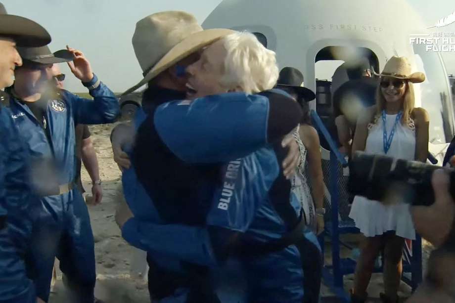 Jeff Bezos luego de descender de la cápsula. En la imagen está abrazando a  Wally Funk,  la pionera de la aviación.