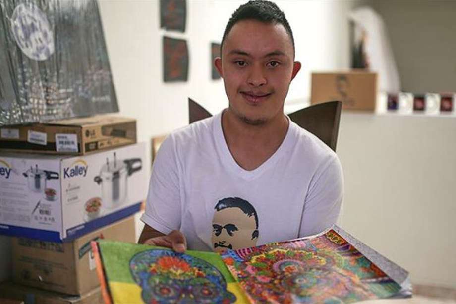 Franco Parra, de 22 años, posa en su estudio, donde pasa horas desarrollando su pasión por la pintura en Bogotá.