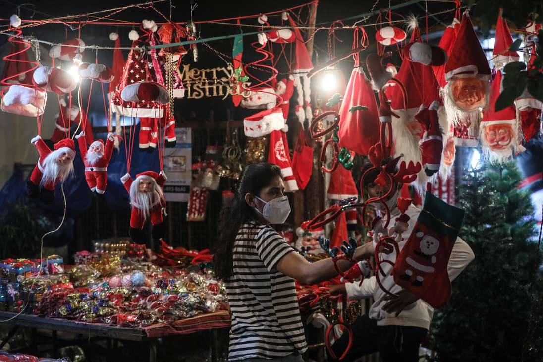 Una mujer india compra artículos decorativos en los puestos de la carretera antes de Navidad, en Mumbai, India.