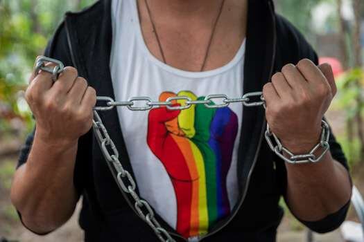 El activista LGBTIQ Koddy Campo es visto hoy encadenado como protesta frente a la sede de la Defensoría del Pueblo, en Caracas (Venezuela).