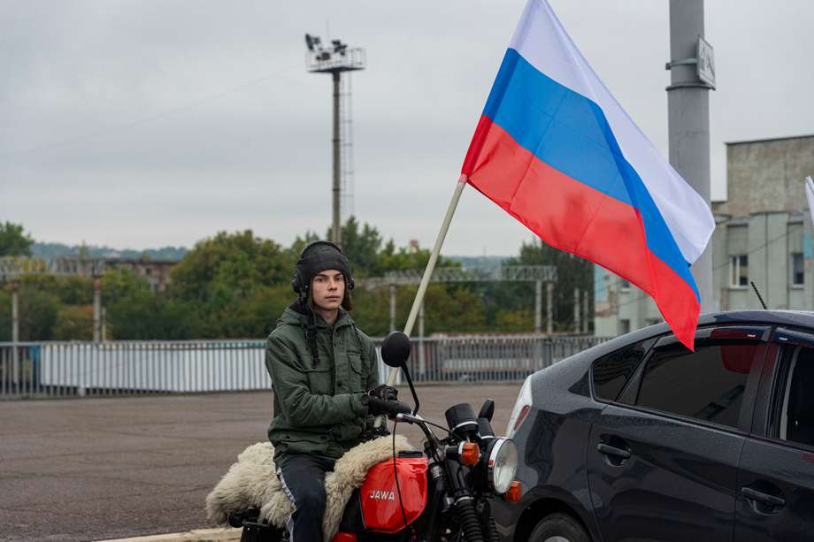 Un motociclista ondeó una bandera rusa y asistió a un mitin de automóviles en apoyo de un referéndum para unirse a la Federación Rusa en Lugansk, Ucrania, el 23 de septiembre de 2022. 
