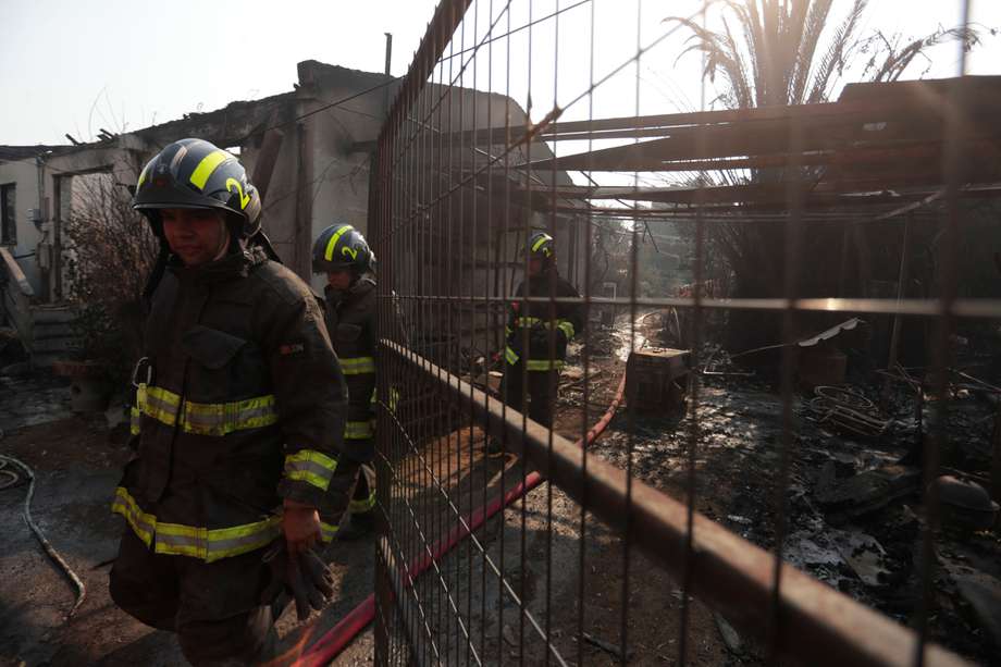Bomberos trabajan en el control y extinción de un incendio hoy, en la zona de Patagual, en Viña del Mar (Chile). 