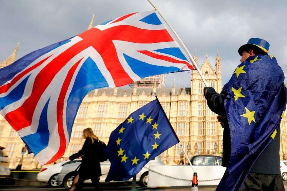 En esta foto de archivo tomada el 28 de marzo de 2018, un manifestante anti-Brexit ondea una bandera del Reino Unido frente a las Casas del Parlamento en Londres.