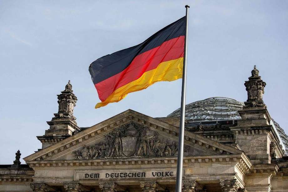 La bandera nacional alemana ondea frente al edificio del Reichstag que alberga el Bundestag (la cámara baja del parlamento alemán) en Berlín.