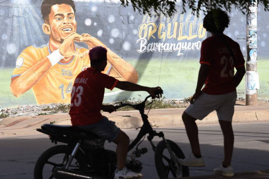 Los fanáticos de la estrella del fútbol inglés del Liverpool, el colombiano Luis Díaz, miran un mural que lo representa, en Barrancas.