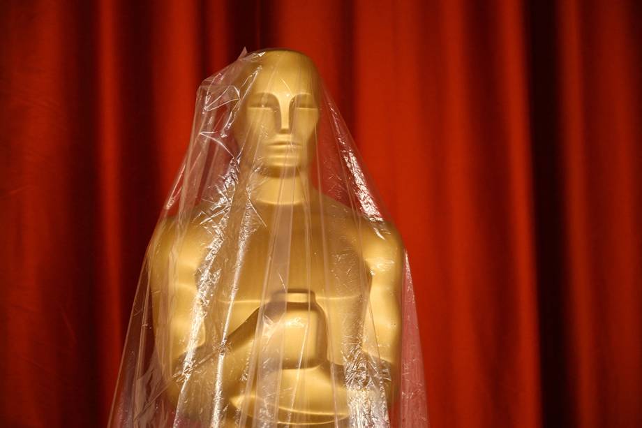 A plastic sheet protects an Oscar statue as rain from a winter storm falls on the red carpet arrivals area, ahead of the 95th Academy Awards, in Hollywood, California, on March 10, 2023. (Photo by Patrick T. Fallon / AFP)