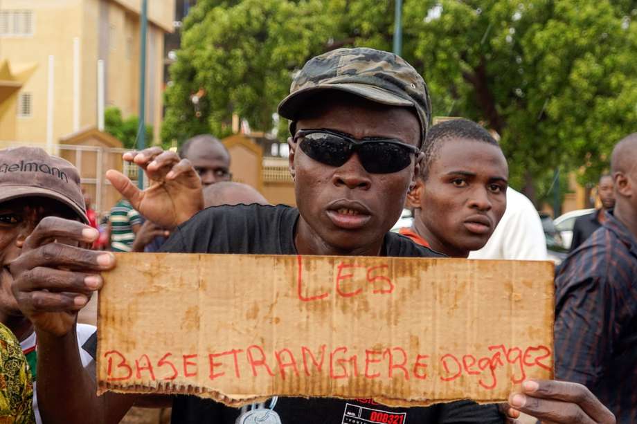 Un partidario de los soldados golpistas en Níger sostiene un cartel que dice "Fuera las bases (militares) extranjeras".