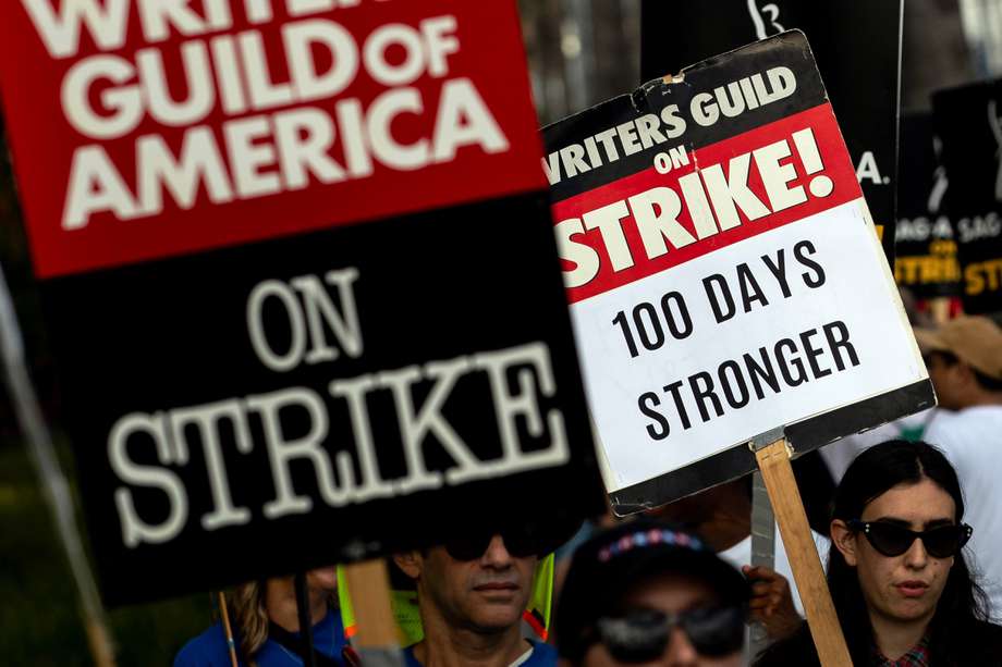Un manifestante sostiene un cartel que dice "100 días más fuertes" mientras los miembros del Sindicato de Escritores de América (WGA) protestan frente a la sede de Netflix en Los Ángeles, California. EFE/EPA/ETIENNE LAURENT
