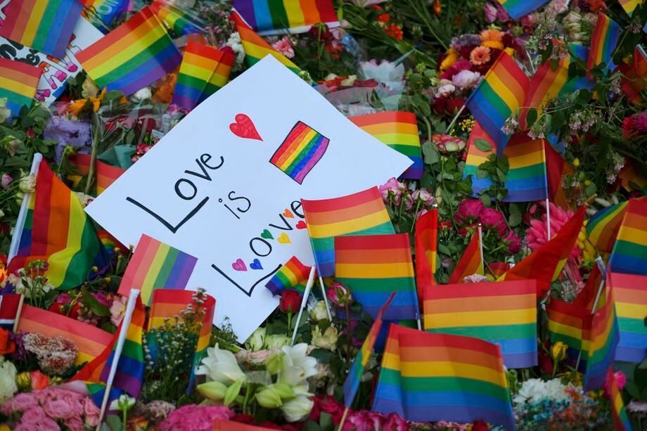 This photograph taken late June 25, 2022, shows flowers and rainbow flags laid after a shooting near an LGBT bar in Oslo. - Norwegian police have arrested a man suspected of "Islamist terrorism" after two people were killed and 21 wounded in shootings near a gay bar in Oslo, causing the city's Pride march to be cancelled. (Photo by Martin Solhaug Standal / NTB / AFP) / Norway OUT