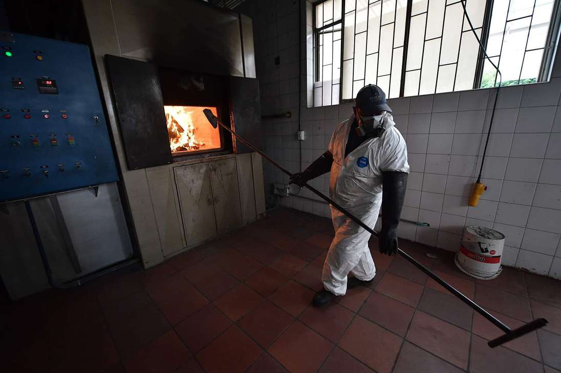 Un hombre frente a un horno crematorio