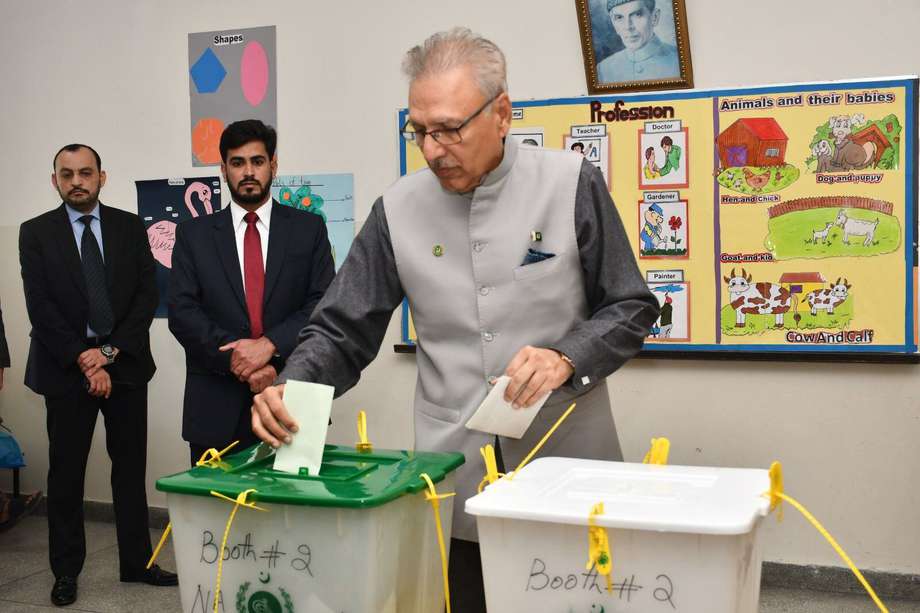 Fotografía facilitada por la División de Medios de Comunicación de la Presidencia de Pakistán que muestra al presidente pakistaní, Arif Alvi (C), depositando su voto en un colegio electoral durante las elecciones generales celebradas en Karachi, Pakistán, el 8 de febrero de 2024. 