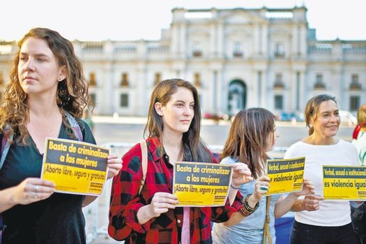Al frente del Palacio de La Moneda, en Santiago, varias mujeres exigen la garantía de sus derechos sexuales y reproductivos. / AFP