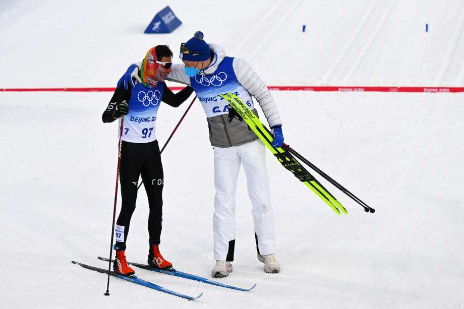 El medallista de oro Iivo Niskanen (derecha), de Finlandia, habla con el colombiano Carlos Andrés Quintana tras su participación en el esquí de fondo en los Olímpicos de Invierno.