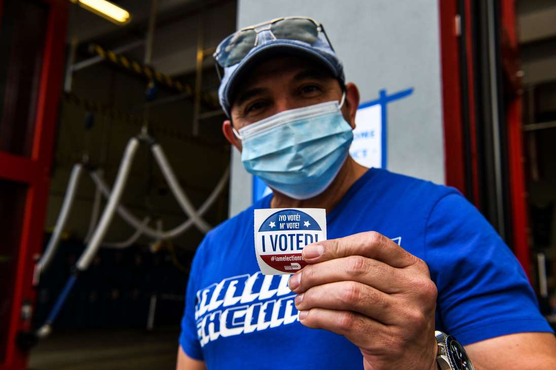 A man shows his "I Voted" sticker after casting his ballot at the Indian Creek Fire Station 4 in Miami, Florida on November 3, 2020. - Americans were voting on Tuesday under the shadow of a surging coronavirus pandemic to decide whether to reelect Republican Donald Trump, one of the most polarizing presidents in US history, or send Democrat Joe Biden to the White House. (Photo by CHANDAN KHANNA / AFP)