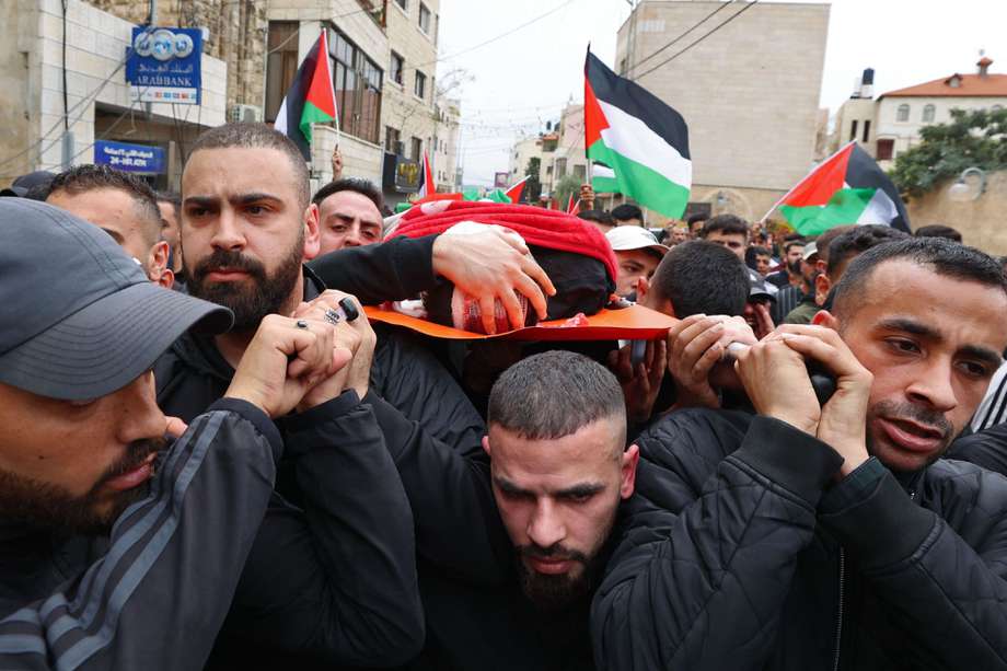 Ciudadanos palestinos cargan el cuerpo de Amir Imad Abu Khadija, quien murió en un operativo policial de Israel.