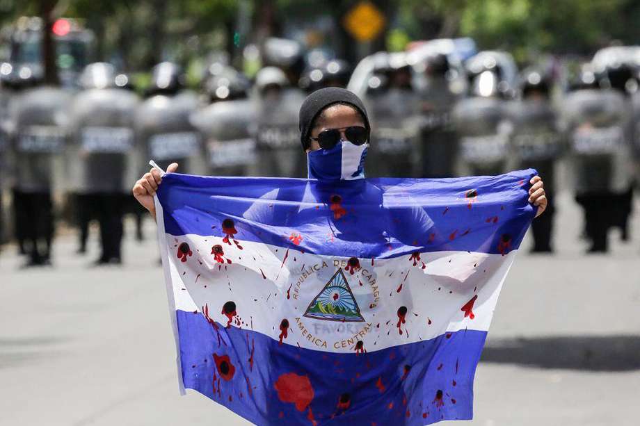 Un manifestante muestra una bandera ensangrentada durante una protesta contra el gobierno del presidente nicaragüense Daniel Ortega, el 16 de septiembre de 2018. 
