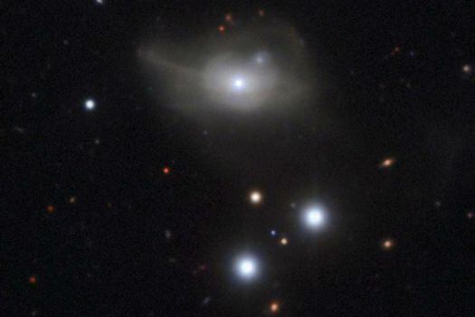 Esta es la galaxia activa Markarian 1018 que tiene un agujero negro supermasivo en su núcleo. Los lazos borrosos que se forman en su alrededor son el resultado de las interacciones con otras galaxias en el pasado. / EFE 