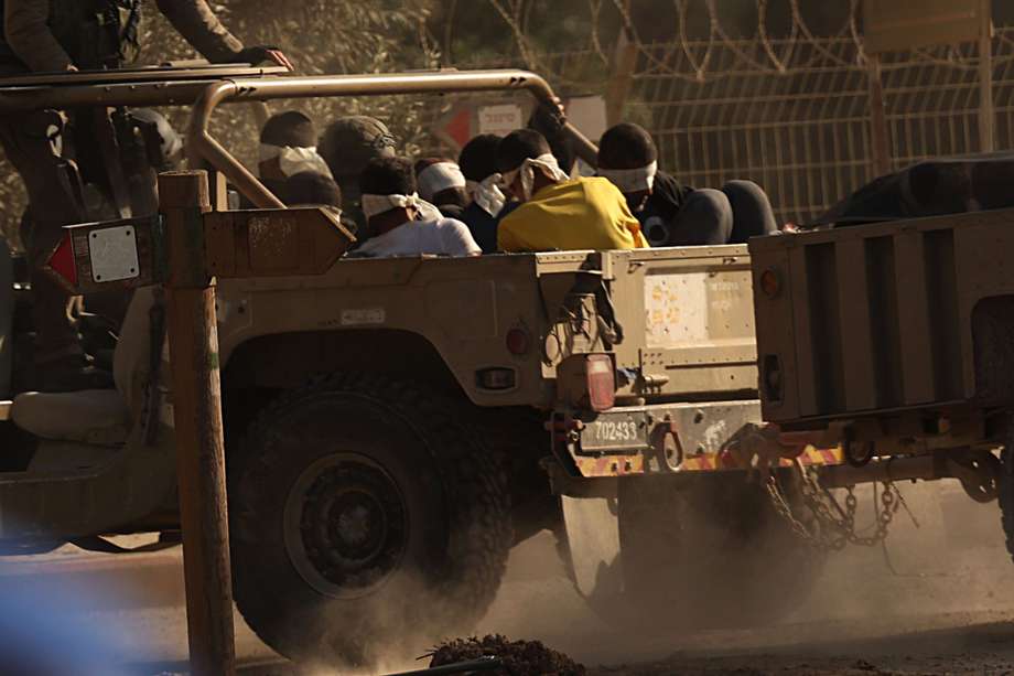  Un vehículo militar israelí transporta prisioneros palestinos que se cree que son militantes de Hamás, este martes, cuando salen de la Franja de Gaza, al sur de Israel. 