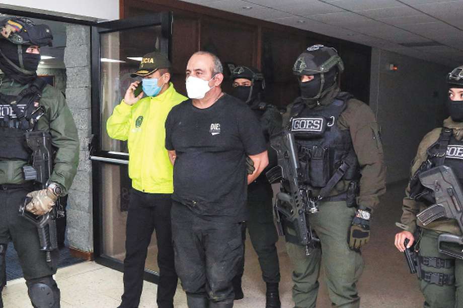 Handout picture released on October 24, 2021 by the Colombian Police press office showing members of the Colombian Army escorting Colombia's most-wanted drug lord and head of the Gulf Clan, Dairo Antonio Usuga (C) -alias 'Otoniel'-, after his capture in Bogota.  Usuga, for whom the United States offered a reward of five million dollars, was captured by Colombian authorities, in Necocli, Antioquia department, the government reported. - RESTRICTED TO EDITORIAL USE - MANDATORY CREDIT "AFP PHOTO / COLOMBIAN POLICE " - NO MARKETING - NO ADVERTISING CAMPAIGNS - DISTRIBUTED AS A SERVICE TO CLIENTS
 (Photo by COLOMBIAN POLICE / AFP) / RESTRICTED TO EDITORIAL USE - MANDATORY CREDIT "AFP PHOTO / COLOMBIAN POLICE " - NO MARKETING - NO ADVERTISING CAMPAIGNS - DISTRIBUTED AS A SERVICE TO CLIENTS
