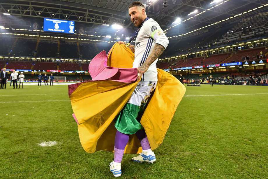 Sergio Ramos en su celebración con el capote de torero y la afición del Real Madrid. / AFP