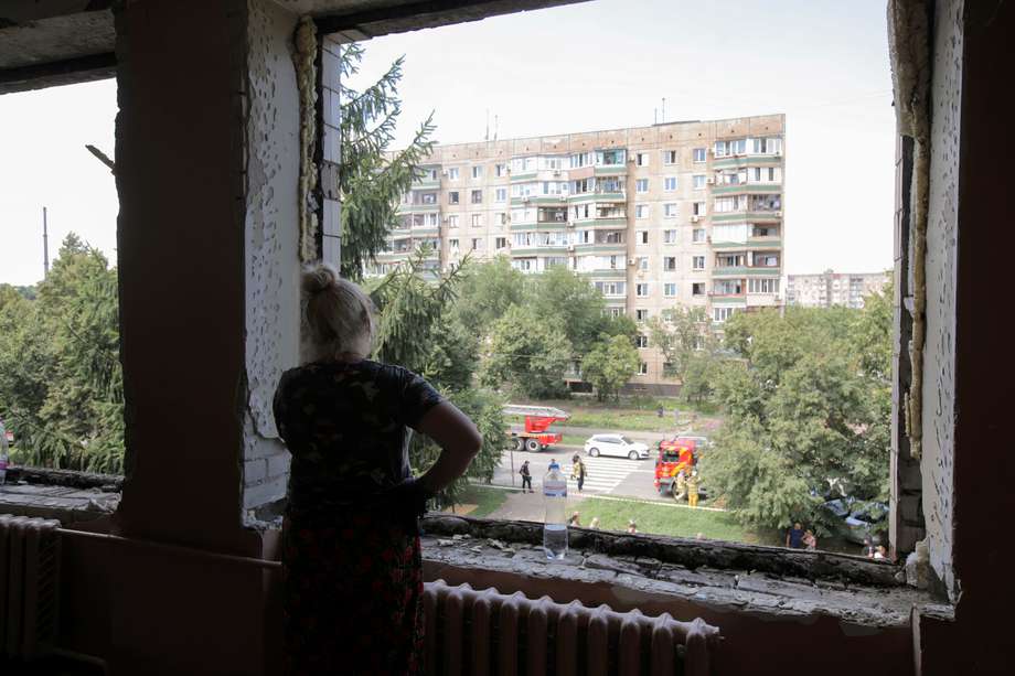 Una mujer se encuentra en una ventana cerca de un edificio residencial dañado tras los bombardeos en la ciudad de Krivói Rog, en el centro de Ucrania. 