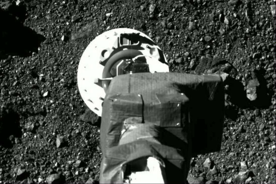 En esta imagen se observa el momento exacto en que la nave espacial, con su brazo robótico, tocó la superficie de Bennu. En el proceso aplastó las rocas porosas que estaban en el suelo.