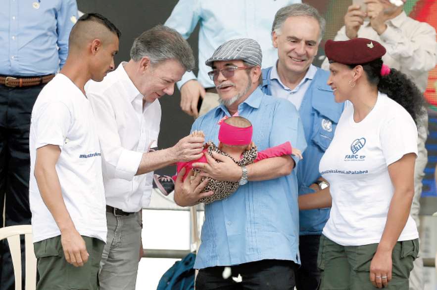 Timoleón Jiménez, “Timochenko” le presentó en tarima, al residente Juan Manuel Santos, a la bebe de un guerrillero, de siete meses de nacida, como símbolo de los hijos de la paz. / AP