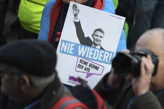 Un manifestante sostiene un póster que muestra a Bjoern Hoecke, líder del partido AfD en Turingia, levantando su brazo y subtituló "Nunca más". Fotografía del 15 de febrero.  / AFP