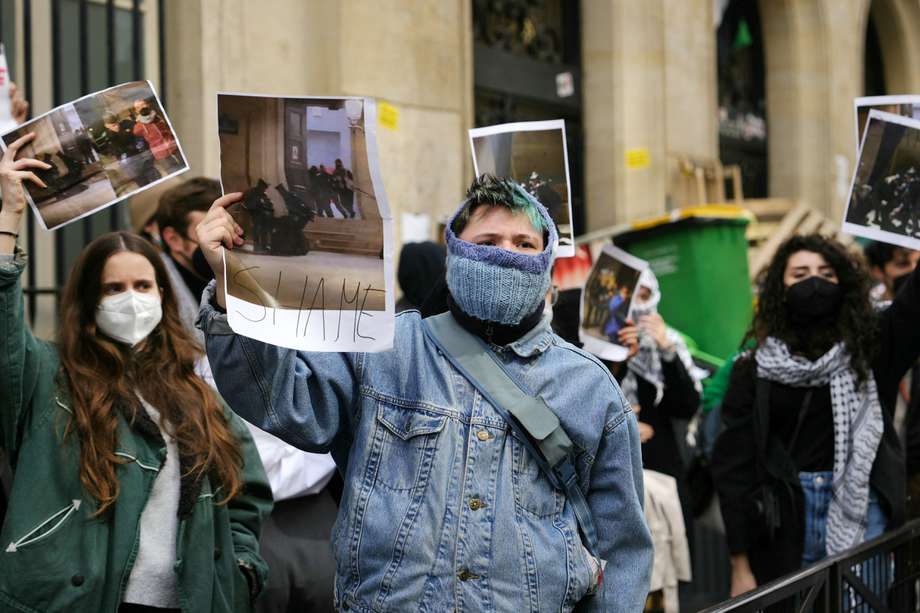 Los manifestantes levantan fotografías mientras los estudiantes ocupan un edificio del Instituto de Estudios Políticos (Sciences Po Paris) por estudiantes en apoyo de los palestinos, en París el 26 de abril de 2024.

