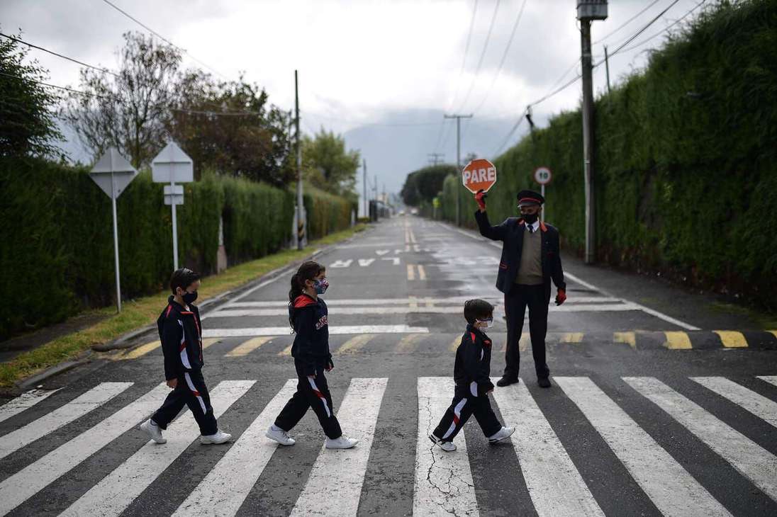 Tres niños atravesando la calle.
