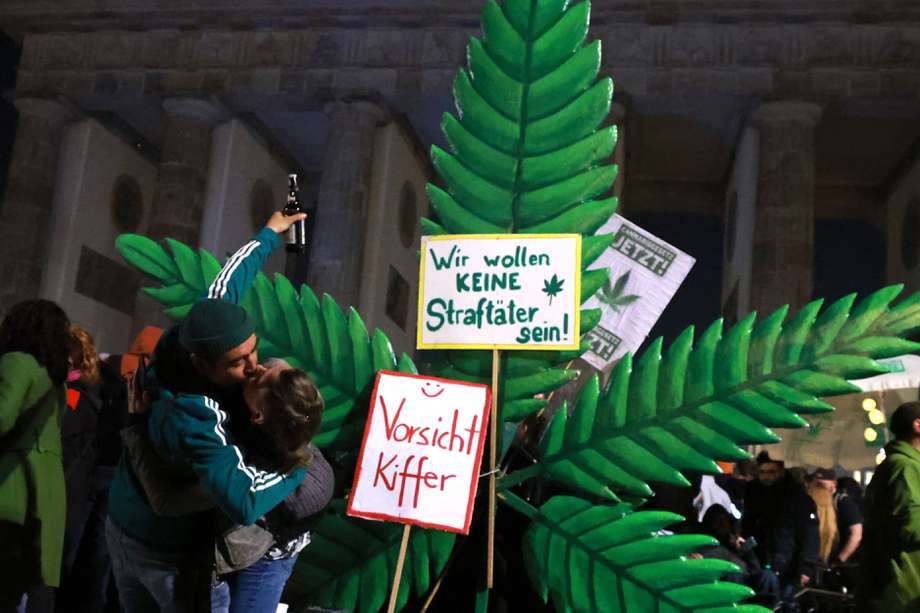 Participantes de un encuentro a favor de la legalización del cannabis con fines recreativos se besan en Berlín, Alemania. 