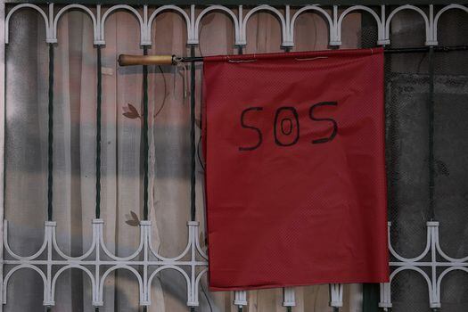Las personas que están en busca de ayudas han optado por colocar telas y trapos rojos a las afueras de sus viviendas para alertar por la falta de recursos.  / Mauricio Alvarado - El Espectador.